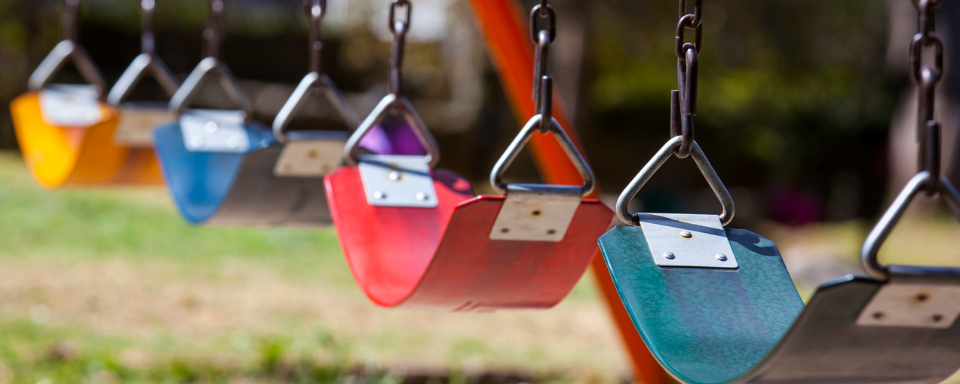 A row of multicoloured playground swings.