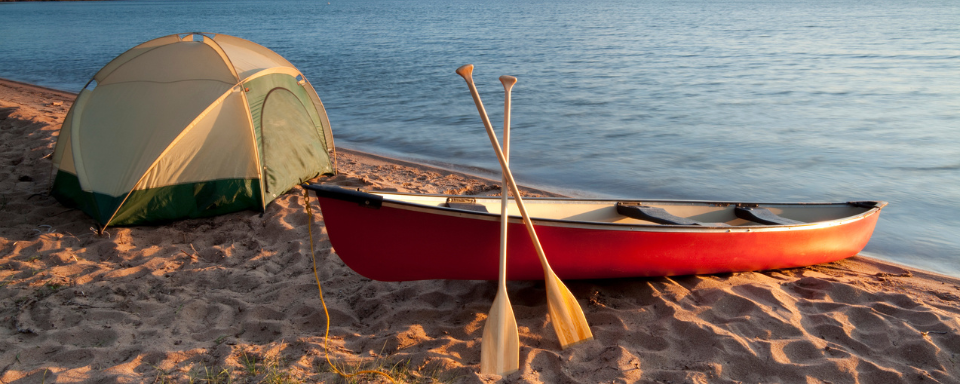 Un canot et une tente sur le bord du lac.