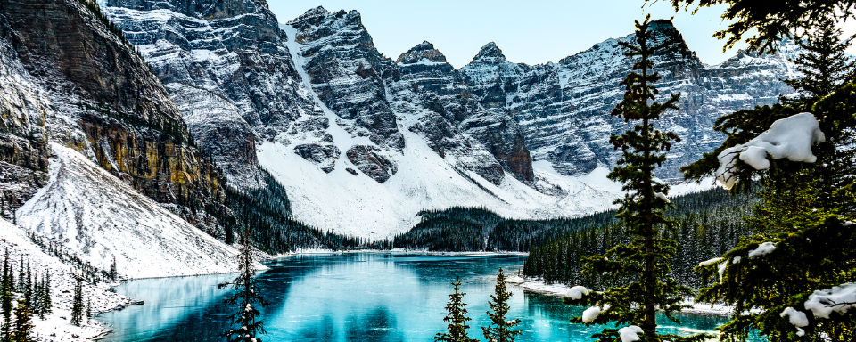 Snowy mountains surrounding a lake with turquoise waters.