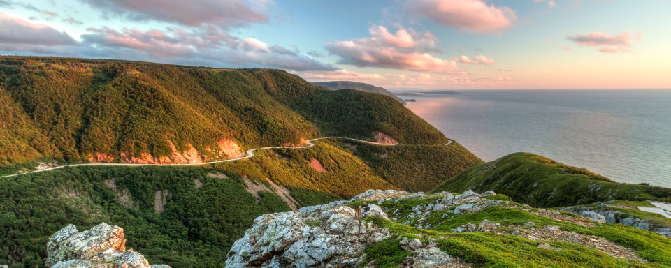 Green cliffs overlooking the sea at sunset in Nova Scotia.