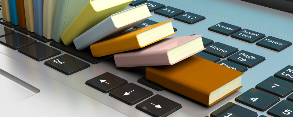 Small books fall over like dominoes on a laptop keyboard.